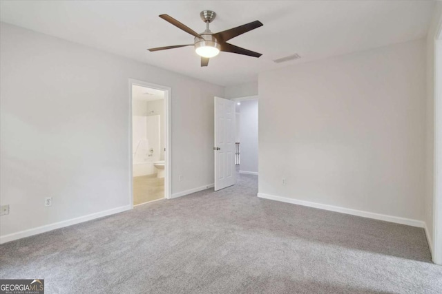 unfurnished bedroom featuring carpet, ensuite bathroom, visible vents, baseboards, and ceiling fan