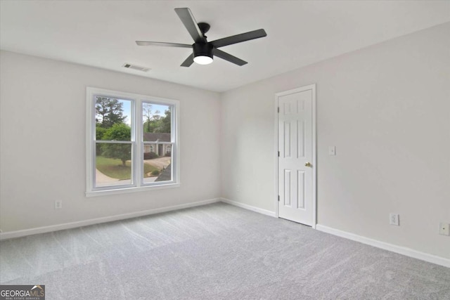 empty room with ceiling fan, carpet, baseboards, and visible vents