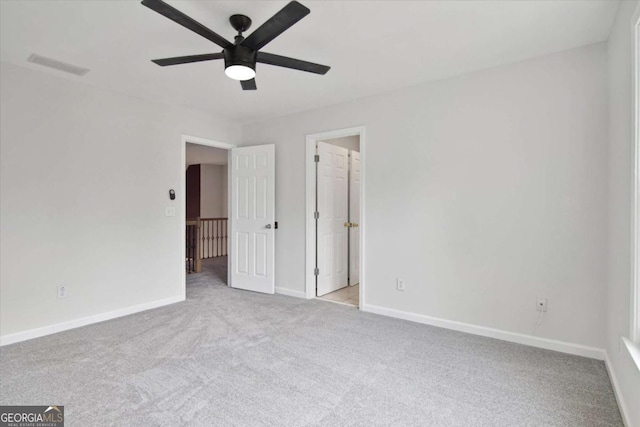 unfurnished bedroom with carpet, visible vents, baseboards, and ceiling fan