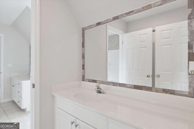 bathroom with lofted ceiling, tile patterned flooring, and vanity