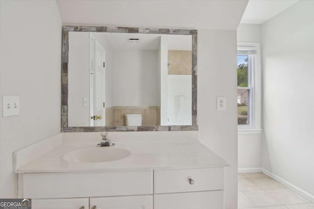 bathroom featuring vanity, toilet, baseboards, and tile patterned floors