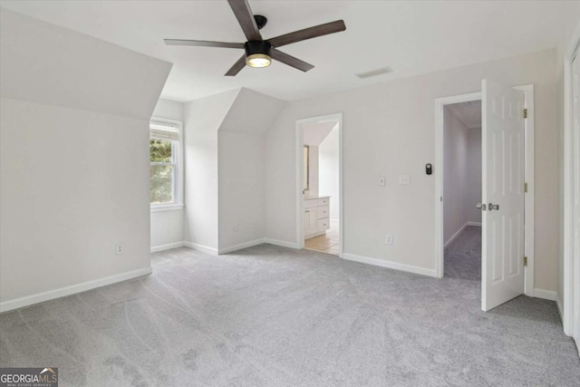 unfurnished bedroom with light colored carpet, ensuite bathroom, visible vents, and baseboards