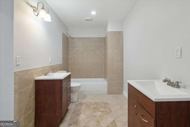 full bathroom featuring toilet, shower / tub combination, tile walls, visible vents, and vanity