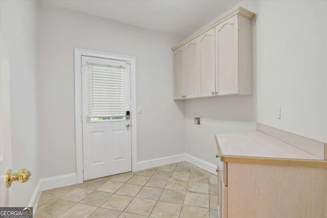 laundry area featuring hookup for a washing machine, light tile patterned flooring, cabinet space, and baseboards