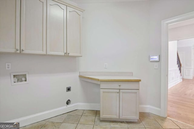 laundry area featuring electric dryer hookup, cabinet space, hookup for a washing machine, and light tile patterned floors