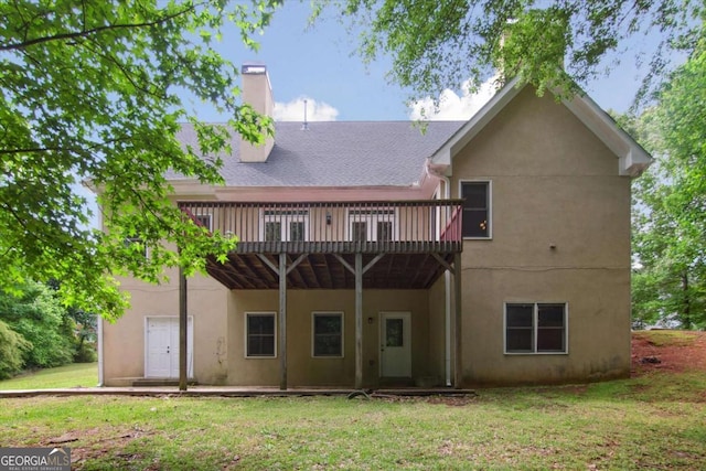 back of house with stucco siding, a yard, a chimney, and a deck