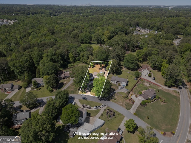 aerial view of property and surrounding area featuring a forest, property parcel outlined, and nearby suburban area