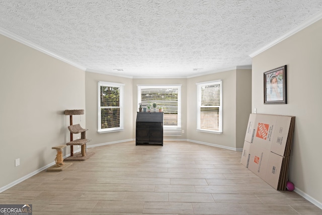 unfurnished room with crown molding, light wood finished floors, a textured ceiling, and baseboards