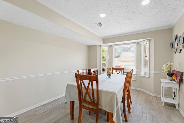 dining room featuring a textured ceiling, crown molding, wood finished floors, baseboards, and recessed lighting