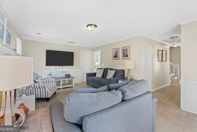 living room featuring a wainscoted wall, stairs, a textured ceiling, and crown molding