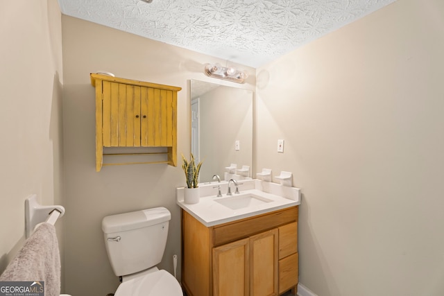 bathroom featuring toilet, vanity, and a textured ceiling