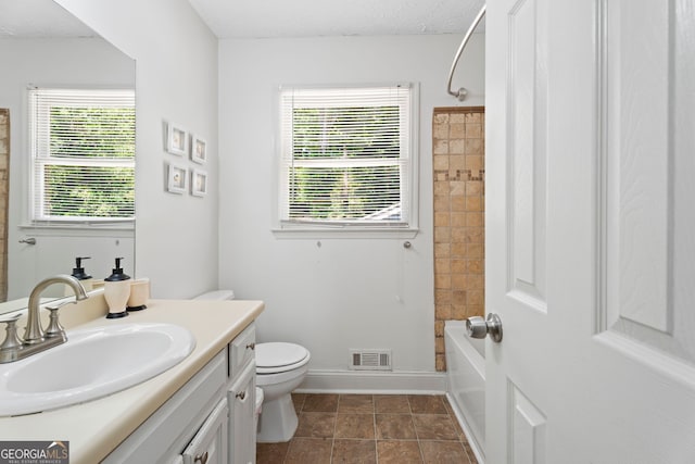 full bathroom with toilet, healthy amount of natural light, vanity, and shower / bathtub combination