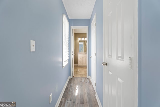 hall with wood finished floors and baseboards