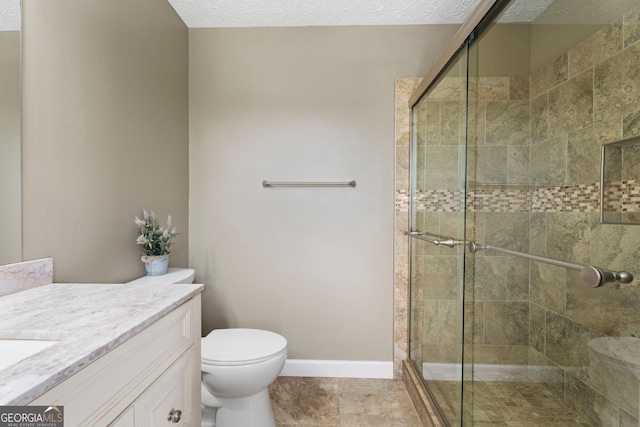 bathroom with a stall shower, vanity, and toilet