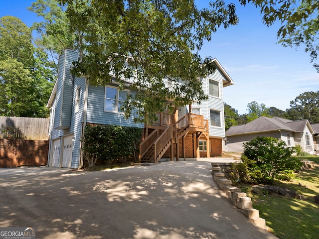 view of front of property with brick siding, stairs, a chimney, a garage, and fence