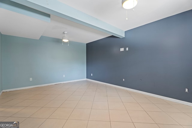 empty room featuring ceiling fan, baseboards, and beam ceiling