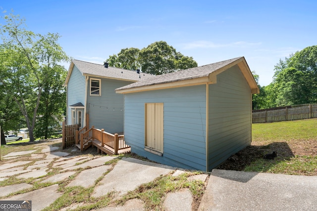 back of property featuring a deck and fence