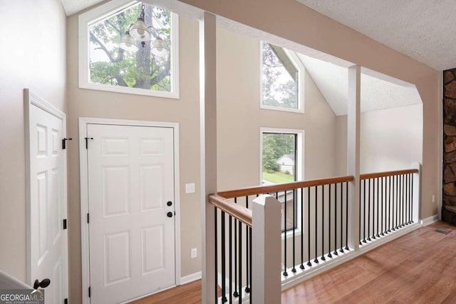foyer with vaulted ceiling, baseboards, and wood finished floors