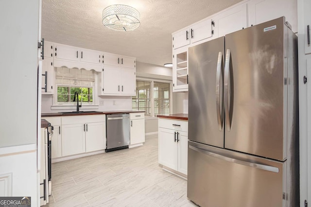 599 Honey Creek Rd, Conyers, GA 30094 - kitchen with appliances with stainless steel finishes, a sink, white cabinetry, wooden counters, and a textured ceiling