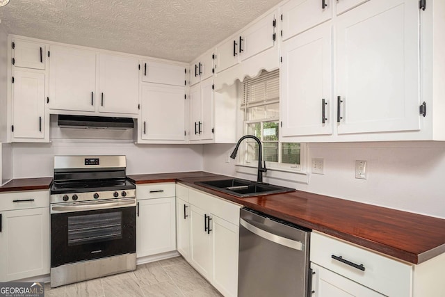 599 Honey Creek Rd, Conyers, GA 30094 - kitchen with stainless steel appliances, a sink, wood counters, white cabinetry, and a textured ceiling