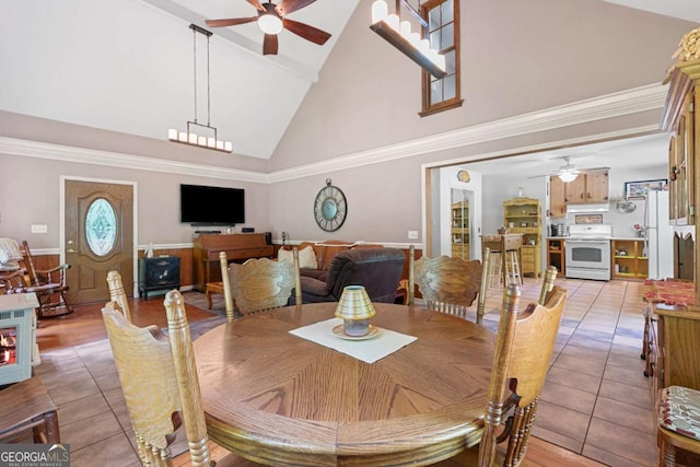 dining area with ceiling fan, high vaulted ceiling, light tile patterned floors, and wainscoting