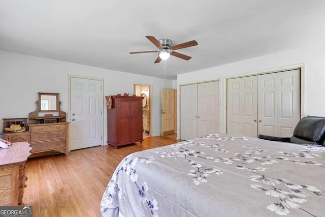 bedroom with light wood-type flooring, two closets, and ceiling fan