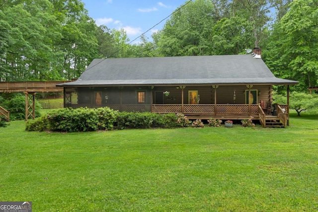 back of property with a yard, a chimney, and log exterior