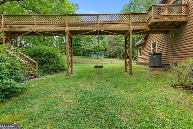 view of green lawn featuring cooling unit and a deck