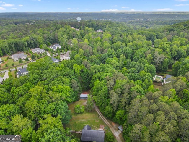 aerial view of property and surrounding area featuring a heavily wooded area