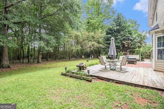 1071 Wildflower Way, Madison, GA 30650 - view of green lawn with a wooden deck, outdoor dining space, and view of scattered trees