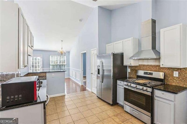 334 Hunterian Pl, Newnan, GA 30265 - kitchen with an inviting chandelier, wall chimney exhaust hood, white cabinetry, appliances with stainless steel finishes, and tasteful backsplash