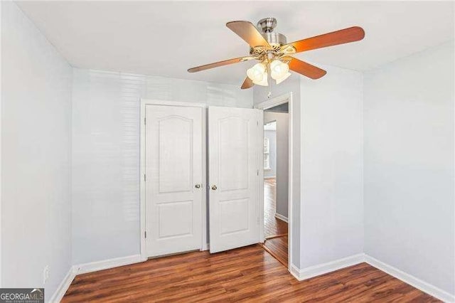 334 Hunterian Pl, Newnan, GA 30265 - unfurnished bedroom with baseboards, a ceiling fan, and wood finished floors