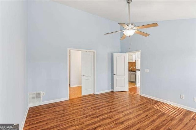 334 Hunterian Pl, Newnan, GA 30265 - unfurnished bedroom featuring baseboards, ceiling fan, visible vents, high vaulted ceiling, and wood finished floors