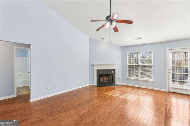 334 Hunterian Pl, Newnan, GA 30265 - unfurnished living room featuring a ceiling fan, lofted ceiling, visible vents, a fireplace with flush hearth, and wood finished floors