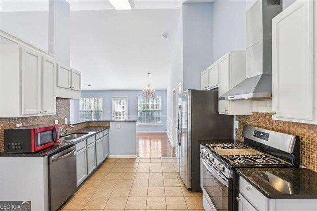 334 Hunterian Pl, Newnan, GA 30265 - kitchen featuring a sink, wall chimney exhaust hood, backsplash, a notable chandelier, and appliances with stainless steel finishes