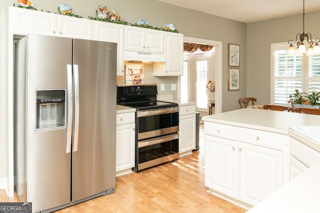 17 Hampton Way, Carrollton, GA 30116 - kitchen with light wood-type flooring, under cabinet range hood, light countertops, a notable chandelier, and appliances with stainless steel finishes