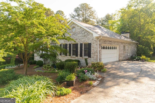 17 Hampton Way, Carrollton, GA 30116 - view of home's exterior featuring brick siding, a garage, a chimney, and driveway