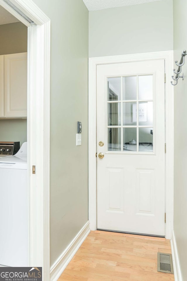 17 Hampton Way, Carrollton, GA 30116 - doorway to outside with baseboards, washing machine and dryer, light wood-style flooring, and visible vents