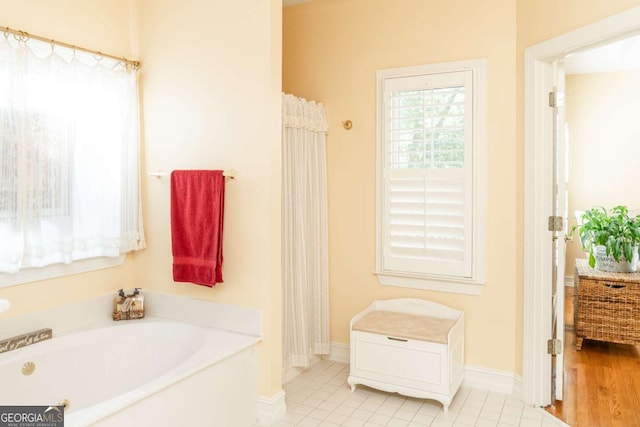 17 Hampton Way, Carrollton, GA 30116 - bathroom featuring a garden tub, baseboards, and tile patterned floors