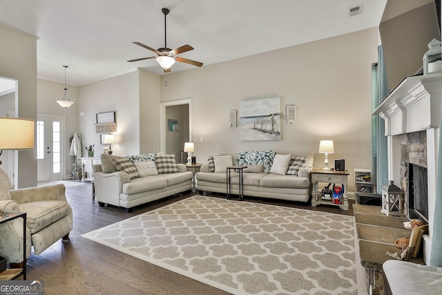 80 Kenwood Trl, Senoia, GA 30276 - living room with a ceiling fan, visible vents, dark wood-type flooring, a fireplace with raised hearth, and ornamental molding