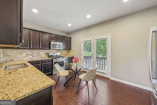 1257 Park Pass Way, Suwanee, GA 30024 - kitchen with baseboards, a sink, dark brown cabinetry, stainless steel appliances, and tasteful backsplash