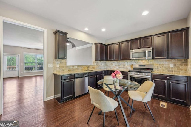 1257 Park Pass Way, Suwanee, GA 30024 - kitchen with dark brown cabinets, a sink, backsplash, appliances with stainless steel finishes, and dark wood-style floors