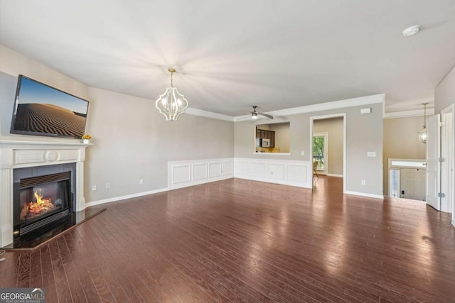 1257 Park Pass Way, Suwanee, GA 30024 - unfurnished living room featuring crown molding, ceiling fan with notable chandelier, a glass covered fireplace, and wood finished floors