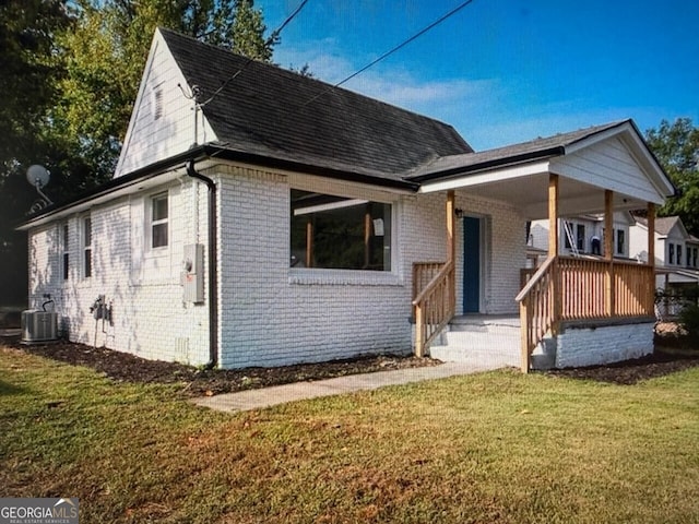 2040 Chicago Ave NW, Atlanta, GA 30314 - view of front facade with brick siding, a front yard, cooling unit, covered porch, and a shingled roof