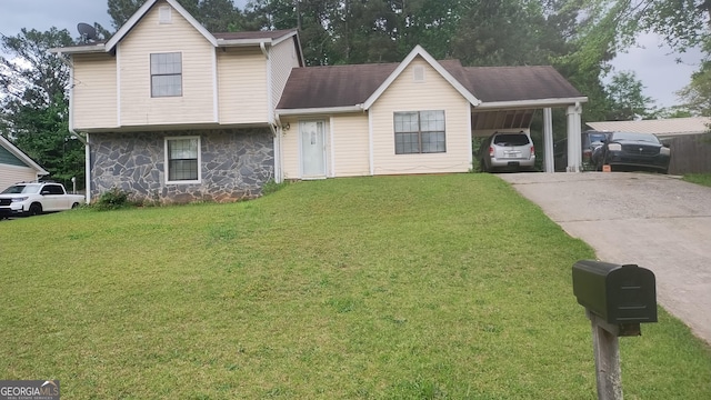 tri-level home featuring stone siding, concrete driveway, a front yard, and a carport