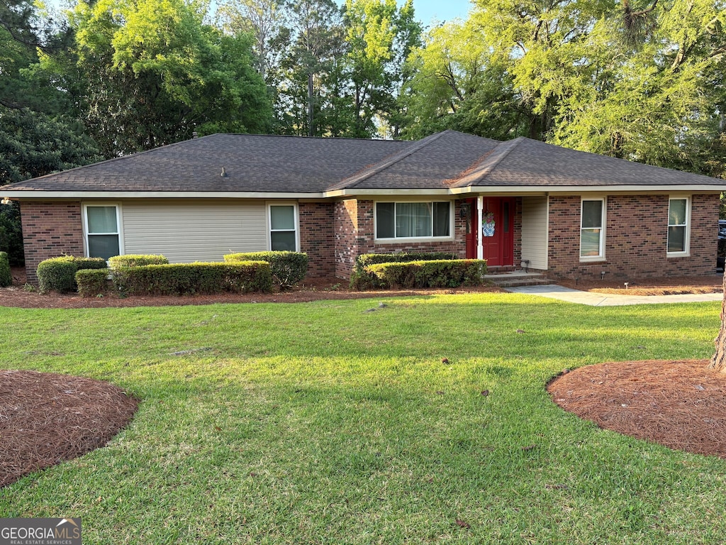 ranch-style home with a front yard and brick siding