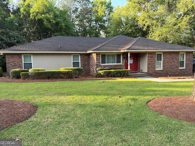 ranch-style home with a front yard and brick siding