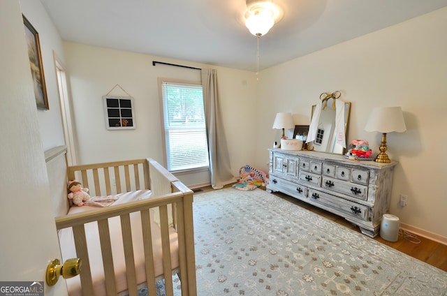 1335 5th Ave, Eastman, GA 31023 - bedroom with a crib and wood finished floors
