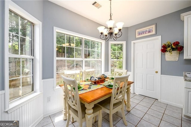 2759 Beddington Way, Suwanee, GA 30024 - dining space featuring a wainscoted wall, light tile patterned floors, a chandelier, and a decorative wall