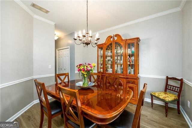 2759 Beddington Way, Suwanee, GA 30024 - dining room with wood finished floors, a chandelier, ornamental molding, and baseboards